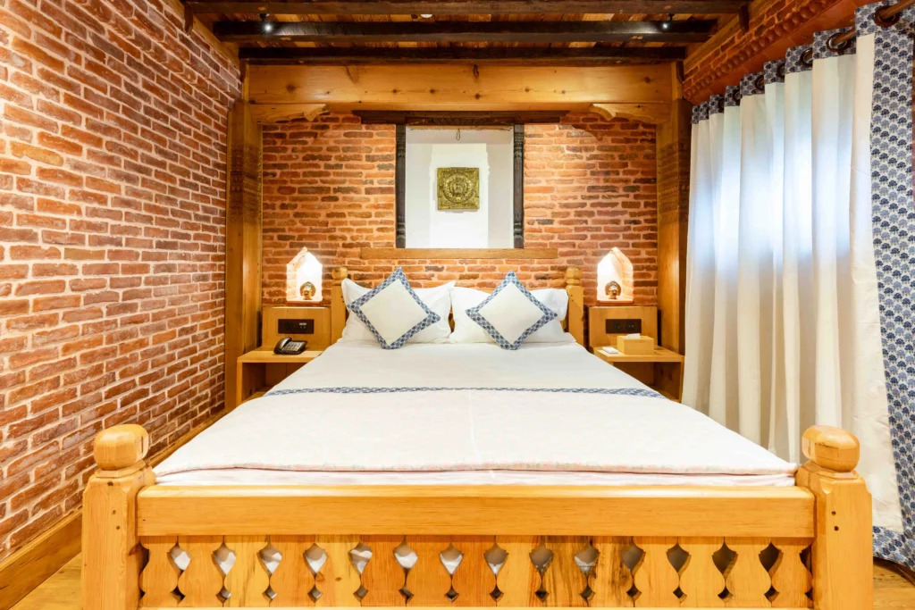Traditionally designed hotel room at Patan with exposed bricks along with other hotel amenities.